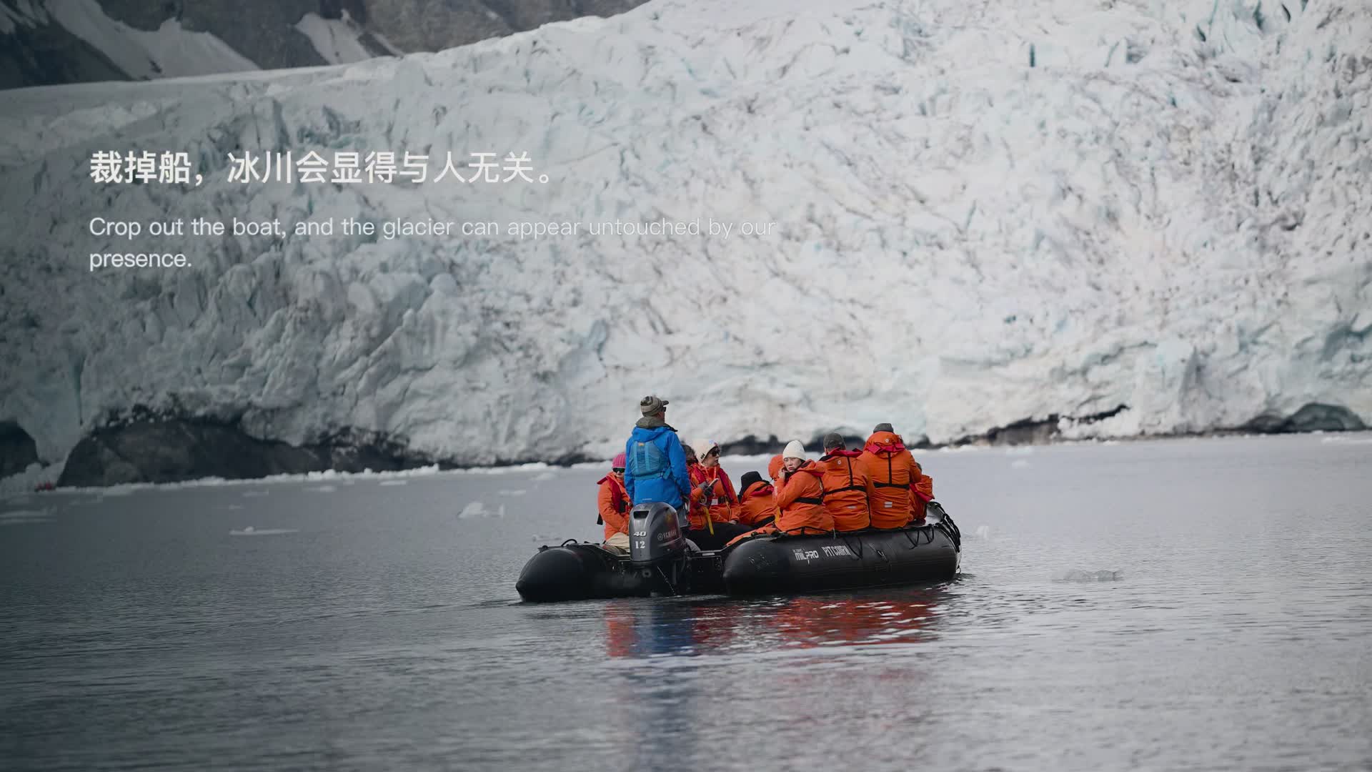 Film still: a Zodiac boat and visitors in front of a glacier